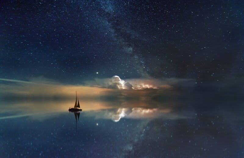 Ocean milky way with silhouette boat